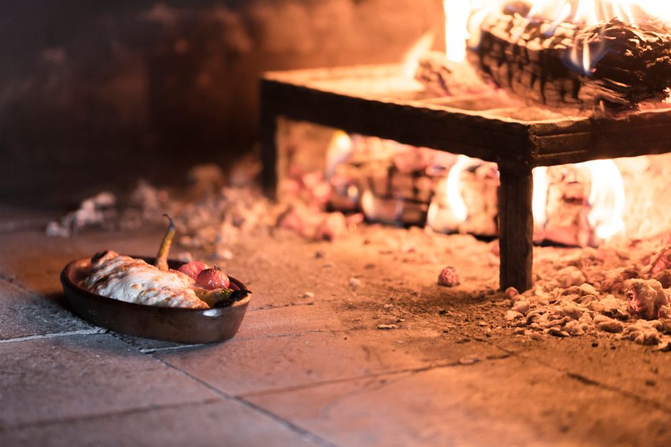 Colourful wood-fired pizza oven in a rustic garden setting