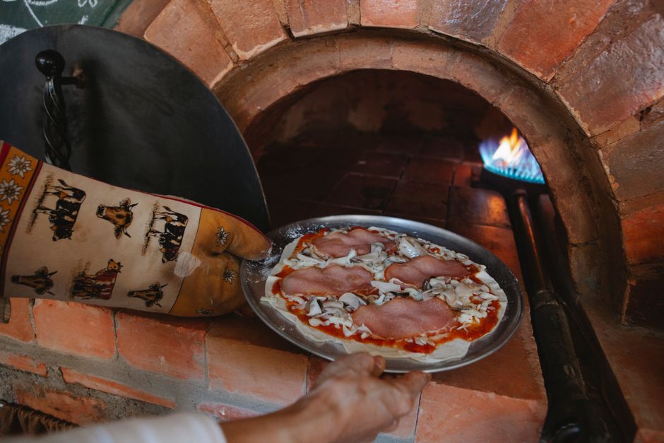 Compact gas pizza oven cooking on a garden patio table