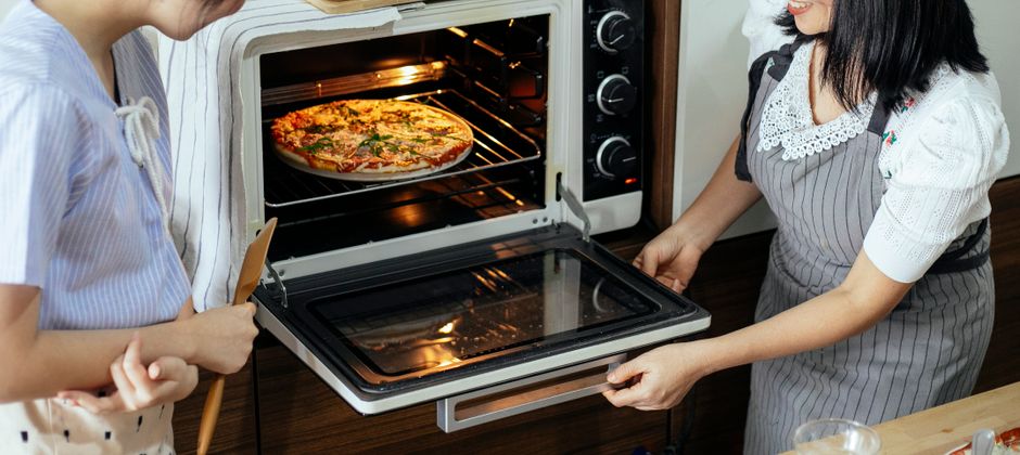 Electric pizza oven baking a pizza on a kitchen counter